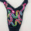 Thumbnail: back of black figure competition suit with neon crystals