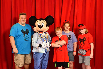 Sheila Smith, Lapeer's Disney travel specialist is meeting Mickey Mouse with her husband, sone, and niece.