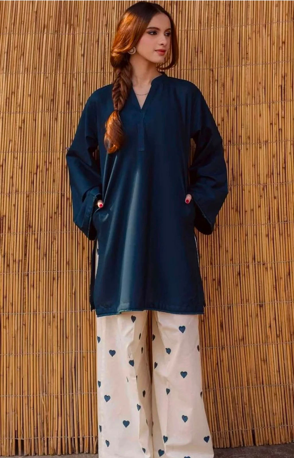 Woman wearing a navy blue long kurta with flared sleeves and off-white heart print wide-leg pants co-ord set