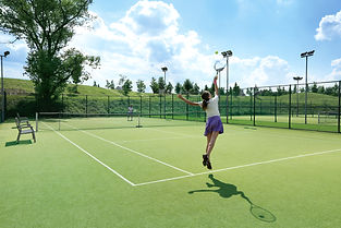 Woman serving tennis ball