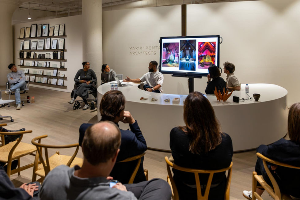 People in a meeting, discussing images on a screen.