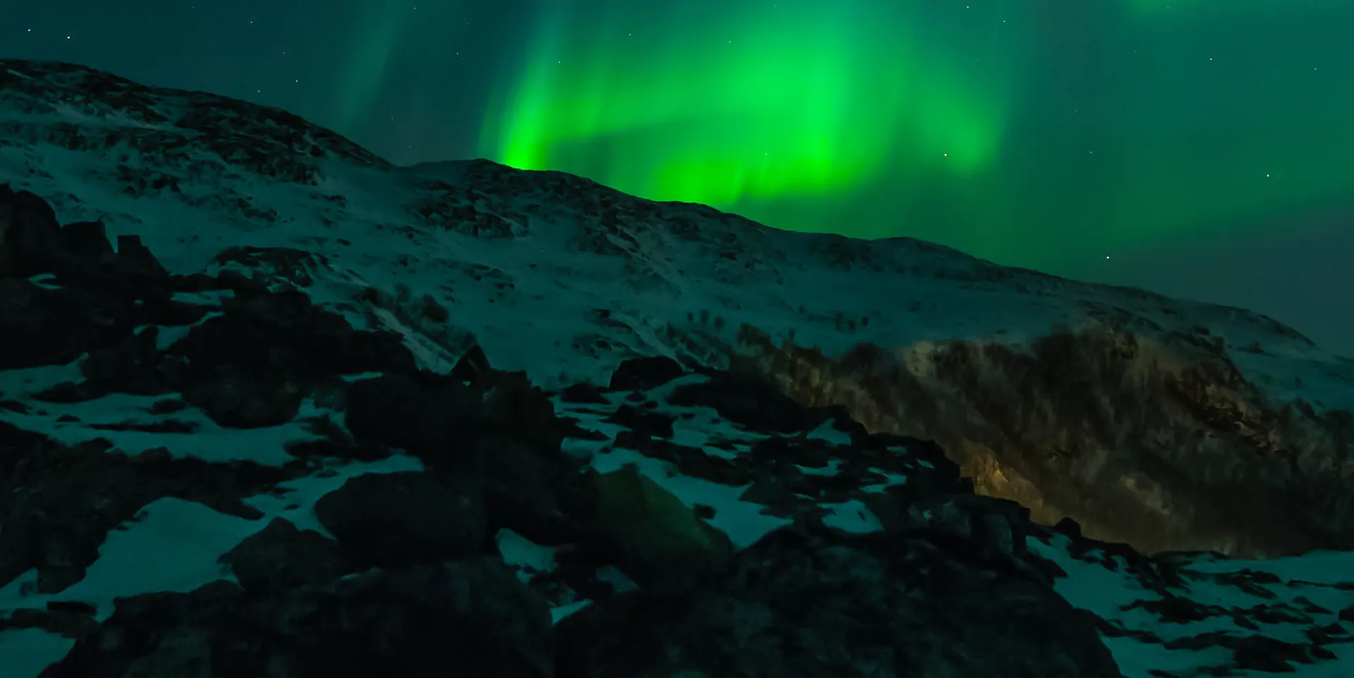 Aurora borealis above a mountain ridge.