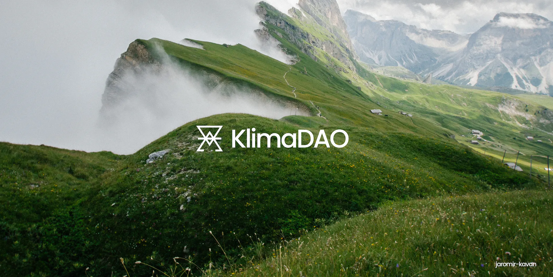 The KlimaDAO logo in front of a green mountain region.