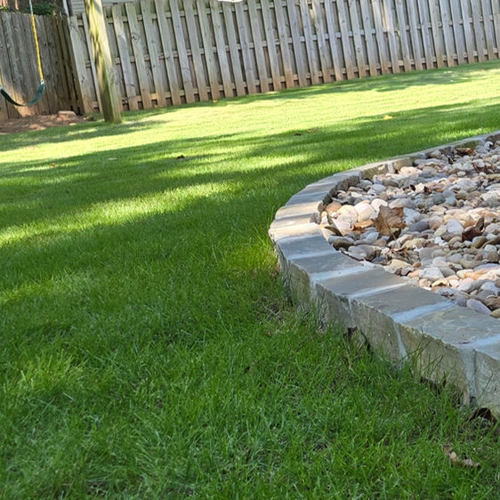 Grey stone edge border with river rock and zoysia sod in Madison AL