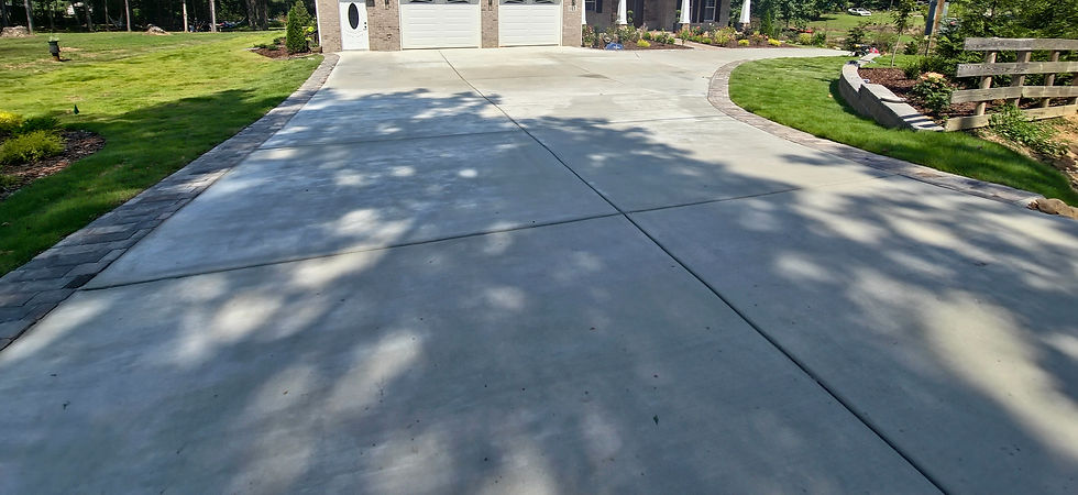 Wide curved concrete driveway with two foot paver border edge around entire perimeter