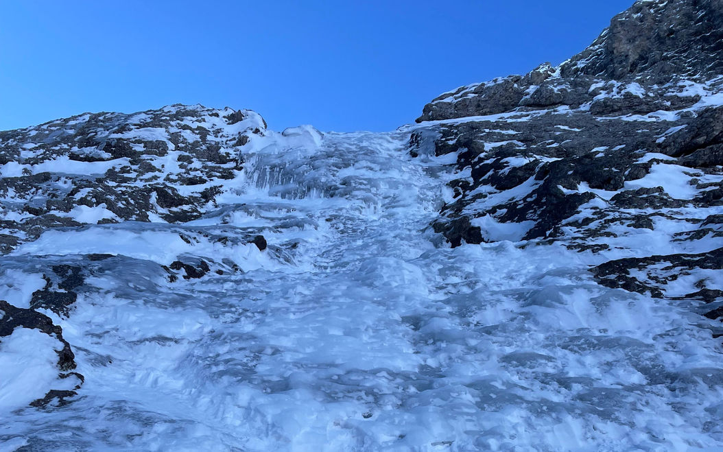 flacher Eisfall in den Dolomiten am Grödner Joch. Eisgeräte im Vordergrund