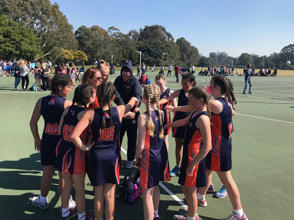 Flames players in a team huddle on the court