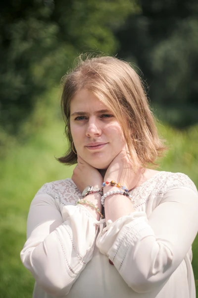 vrouw met witte blouse en edelstenen