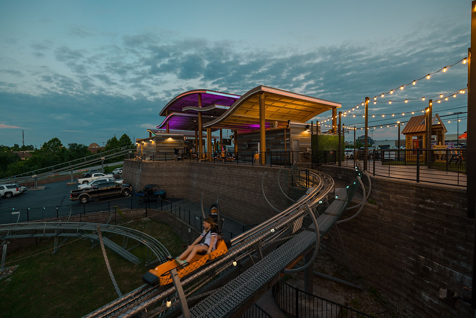 Girl riding and gliding down The Branson Coaster as the sun sets in Branson, Missouri