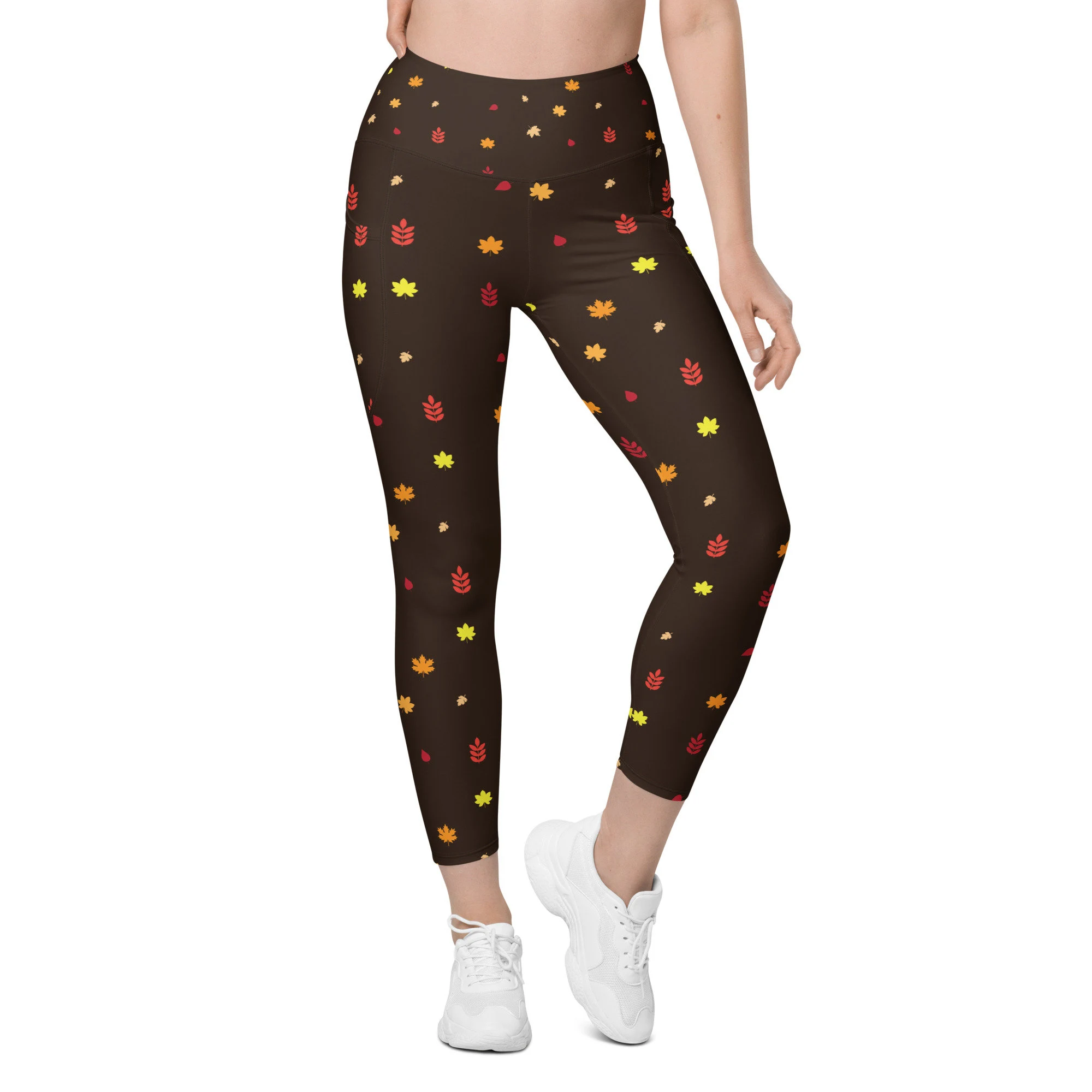 Chocolate brown leggings with pockets with yellow, orange, and red autumn leaves. 