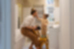 Little girl standing on a stool applying makeup to her Mom's face