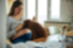 Dog kissing expecting mother's belly