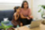 Mother and daughter looking at open laptop