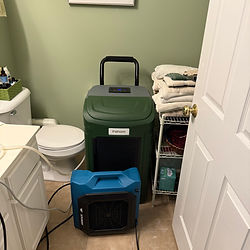 Air scrubber and dehumidifier staged in small bathroom — mold or water remediation equipment by Rock Bottom Restoration.