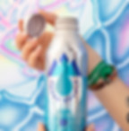 Someone holding up a water bottle in front of an art mural at Bhakti Fest