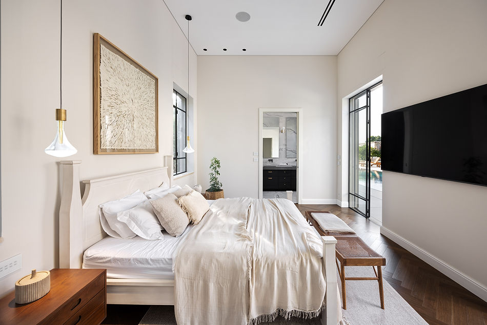 חדר שינה לבן מודרני עם מיטה, טלוויזיה, חלונות ודלתות dikla-pinto.