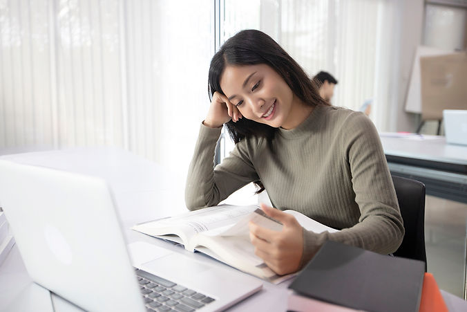smiling-businesswoman-reading-book-desk-office.jpg