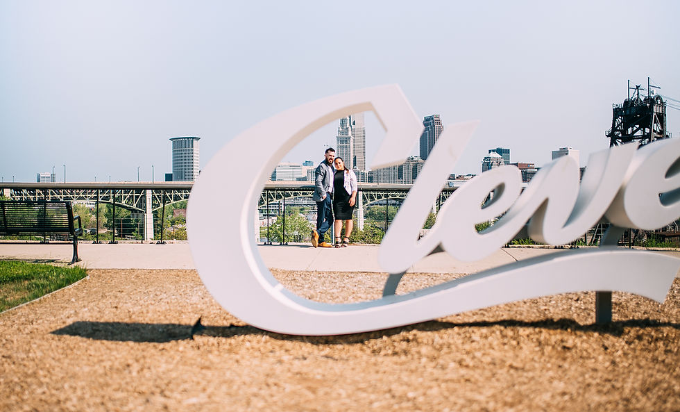 Man and woman portrait through the Cleveland "C" sign