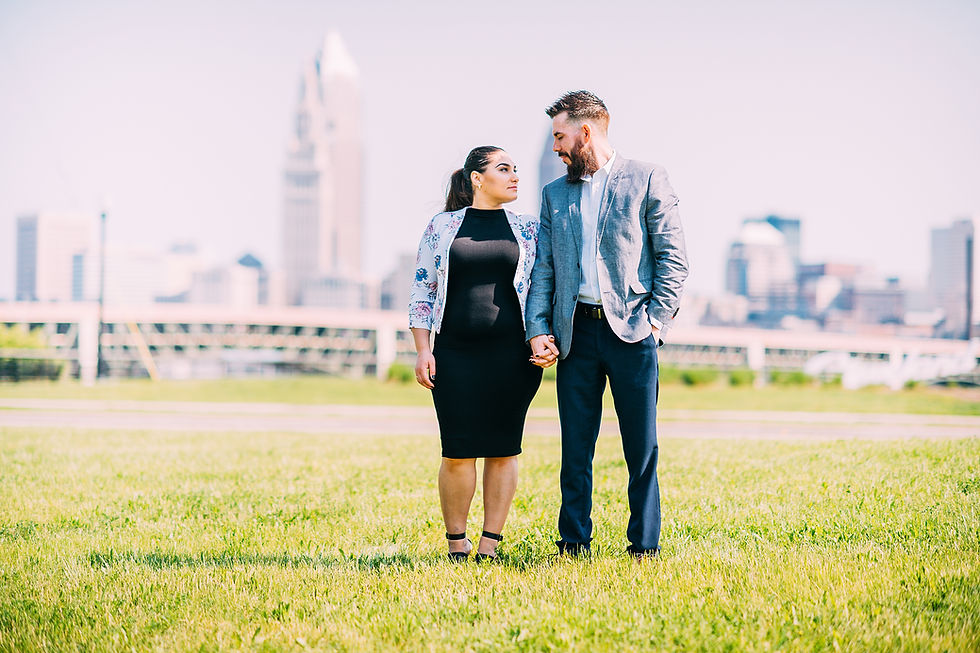 Man and woman stand and look at one another with the city skyline in the background