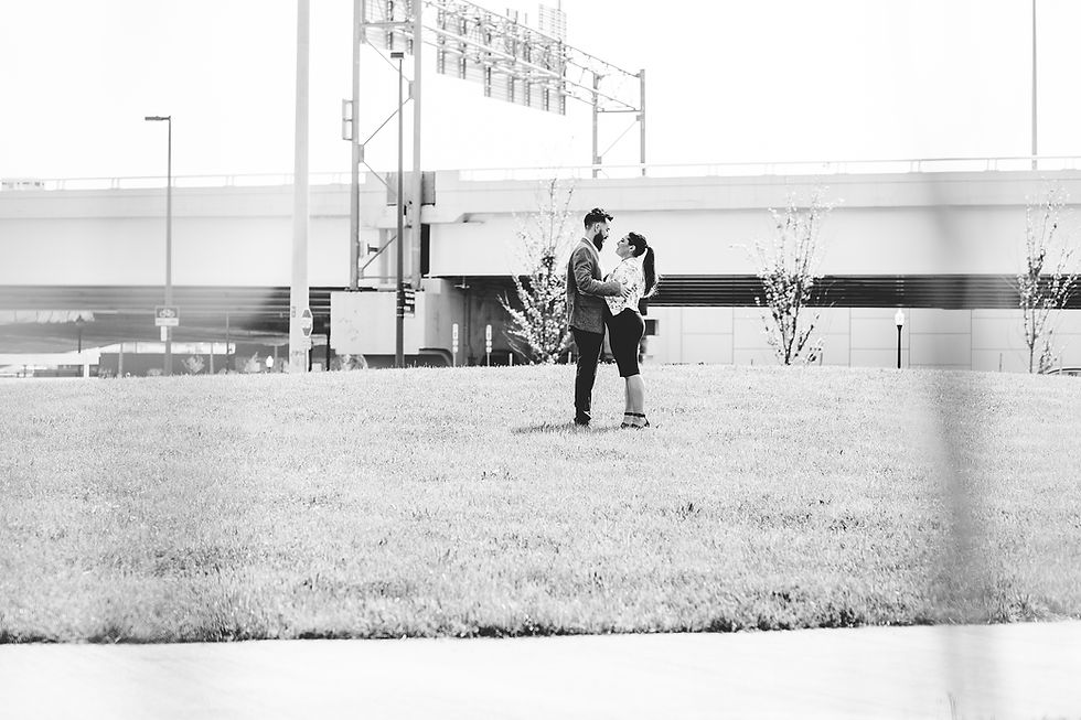 Man and woman stand with one another on a grassy hill in Cleveland