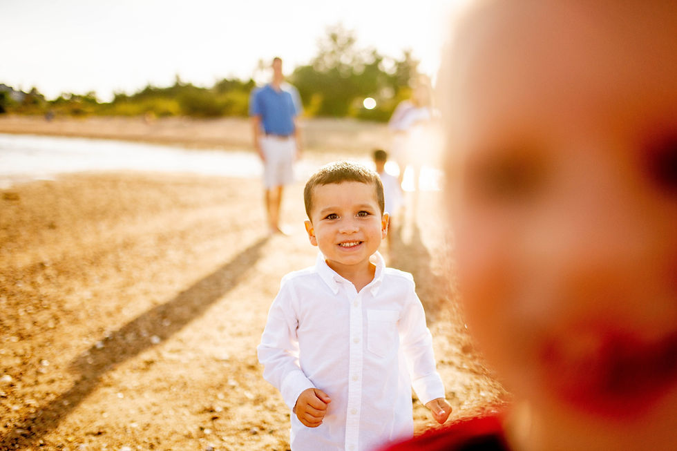 little girl and boy are smiling into the camera at the beach