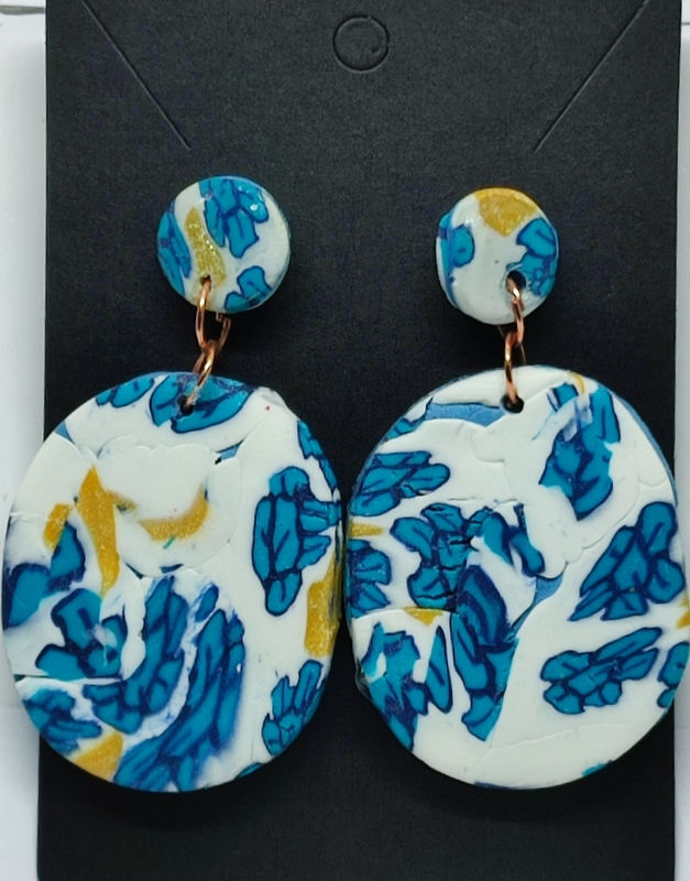 Boucles d'oreilles rondes blanches et bleues, motif floral, détail en cuivre.