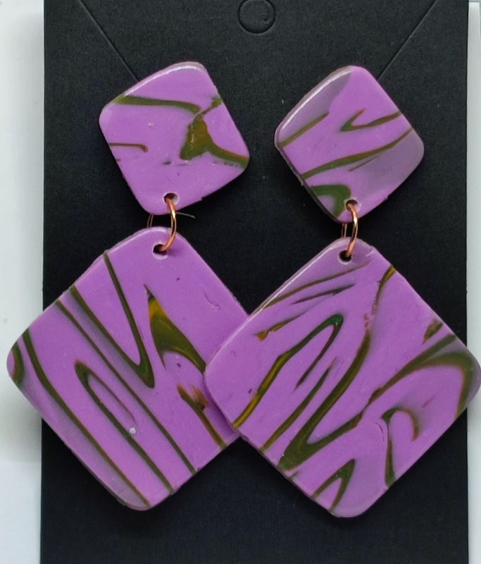 Boucles d'oreilles pendantes lilas avec des motifs et des reflets dorés, Kabo, cinebycine.