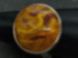 Bague avec un motif tourbillonnant marron et jaune, Bobo, sur fond noir.