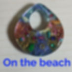 Pendentif artisanal 'On the beach' avec couleurs vives et détails artistiques.