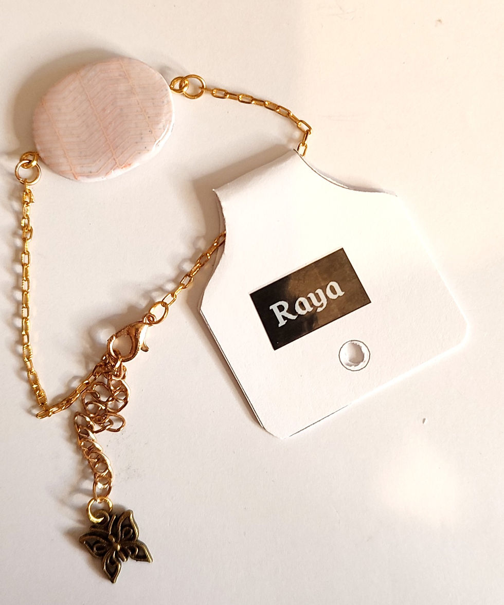 Bracelet Raya avec barrette rose rouge et chaîne dorée, sur fond blanc.