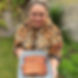 Emmylou holding a plate of roasted, caramelised Char Siu Pork Belly marinated in sweet and savoury sauces with garlic, chilli, and sesame.