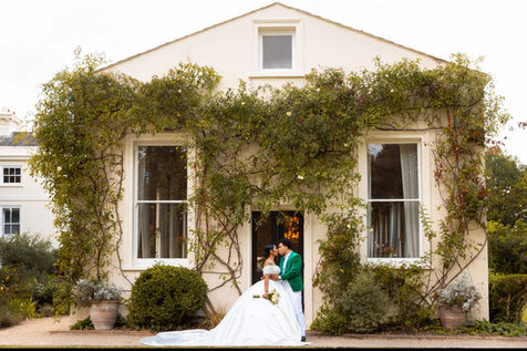 A bride and groom’s kiss at Morden Hall, with the bride holding a bouquet on a beautiful day in London