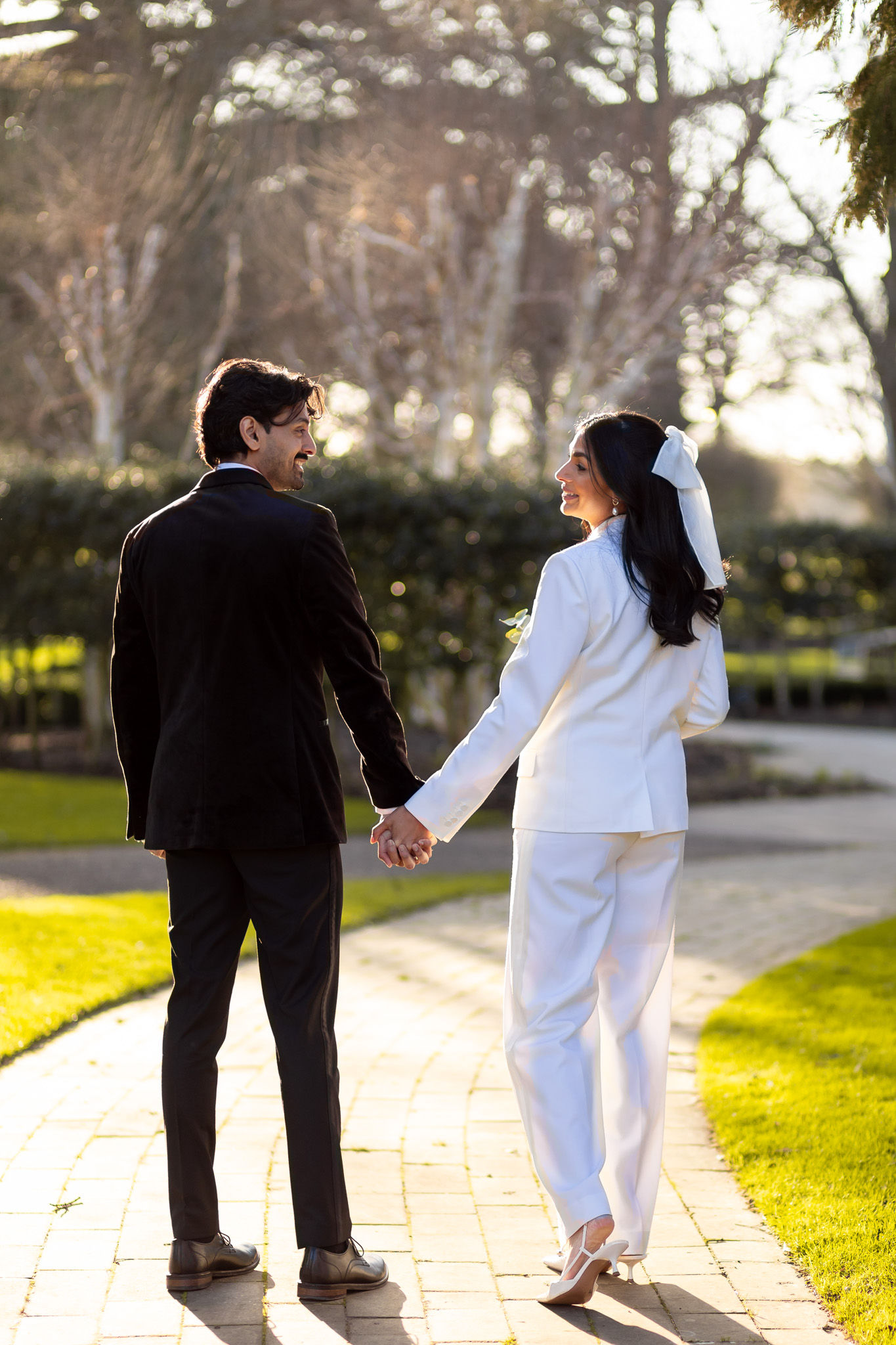 Bride and groom walking through the grounds of The Grove Hotel in Watford
