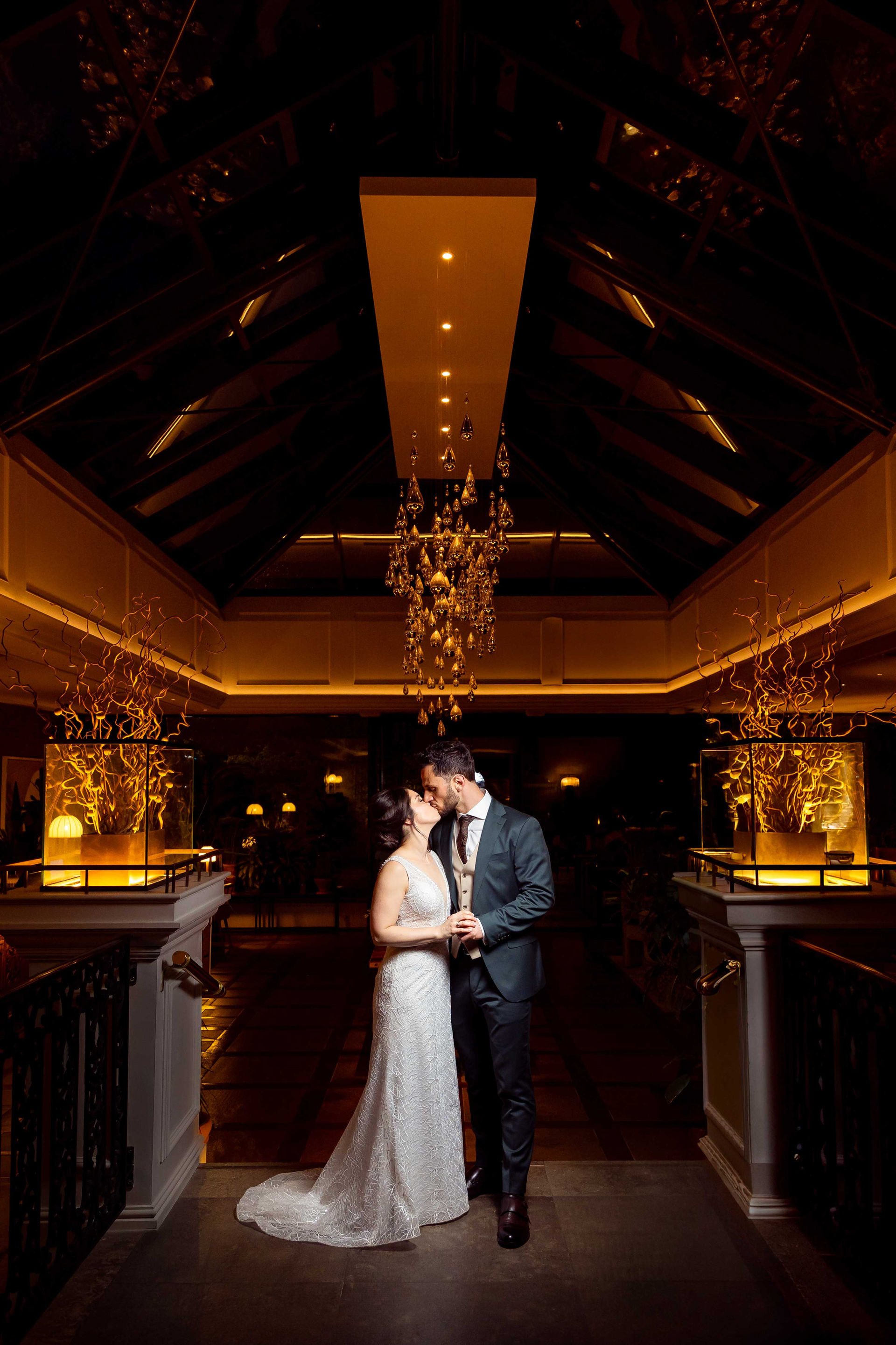 Natalie and Antonis sharing a romantic evening portrait under the chandelier at Sopwell House, captured by Hertfordshire wedding photographer Hektor Lleshi Photography