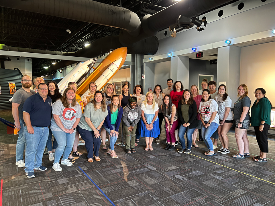 STEM Fellows teachers pose in front of the space shuttle model.