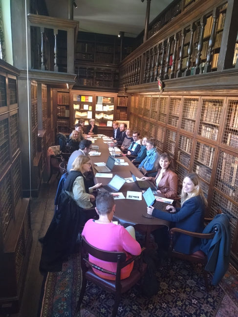 Gruppenfoto der Teilnehmenden des Workshops; sie sitzen alle um einen Tisch in der Bibliothek herum