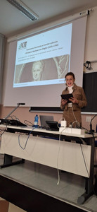 Astrid Dröse hält einen Vortrag, ihre Powerpoint-Präsentation ist im Hintergrund zu sehen