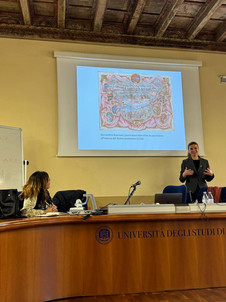 Astrid Dröse hält einen Vortrag, sie steht vor einer Leinwand mit ihrer Powerpoint-Präsentation