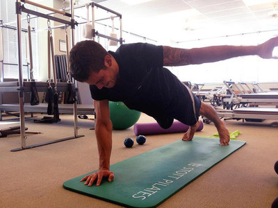 tyler seguin performing a single arm plank stott pilates merrithew pilates mat