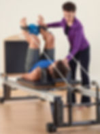 STOTT PILATES instructor teaching client on v2Max Rehab Reformer