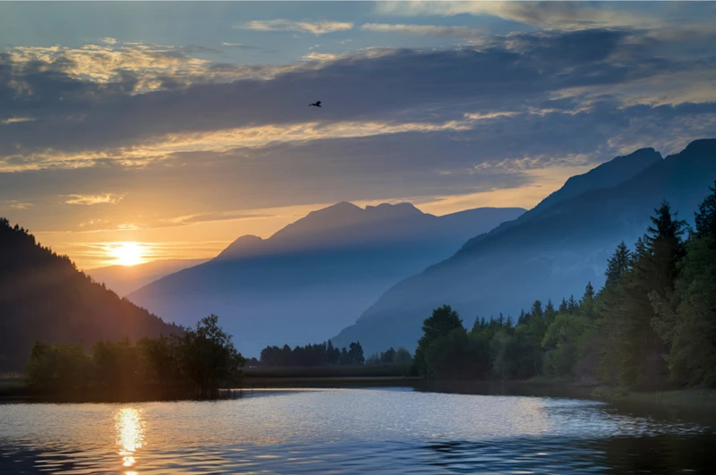 Sunset over mountain lake to depict feelings moving from survival to balance