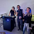 People with DJ, John Hunter, at a silent disco at Palm Folly listening through headphones.