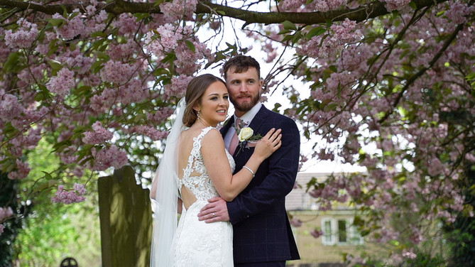 Wedding couple posed by blossom tree Bagden Hall Hotel