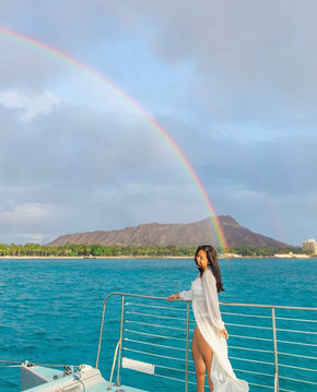 girl on private catamaran in Hawaii with rainbow and Diamond Head