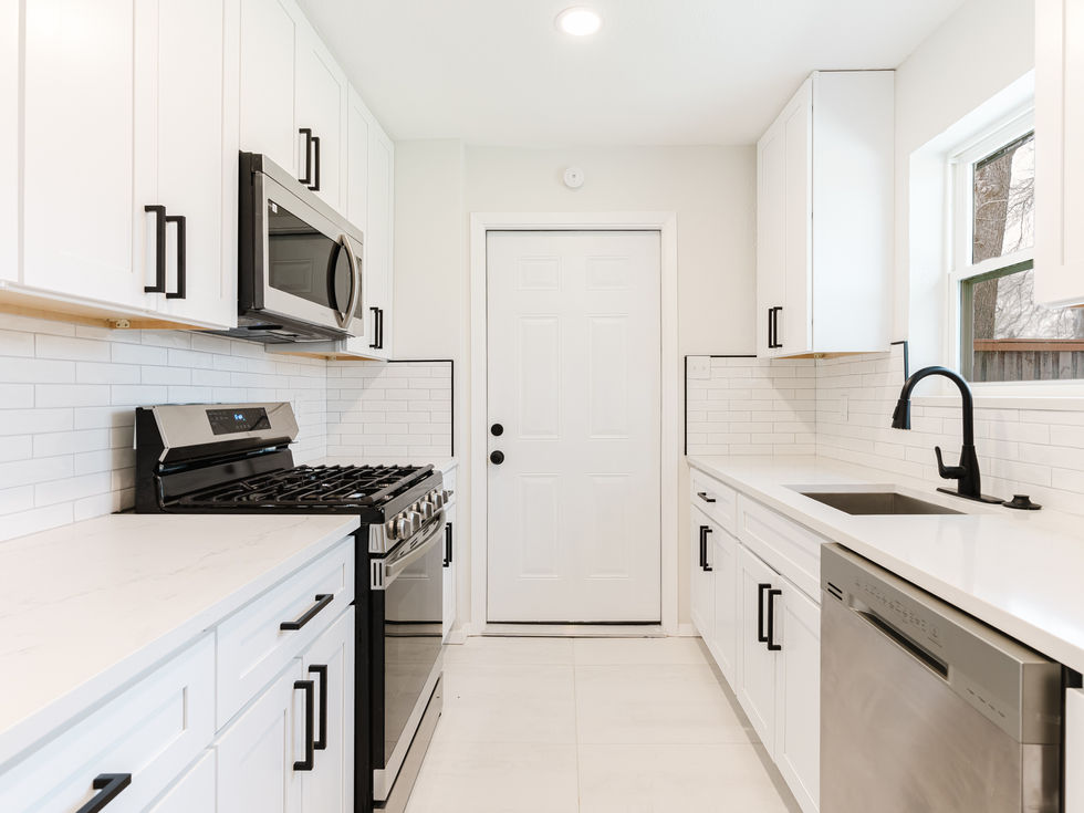 a kitchen with white cabinets and stainless steel appliances