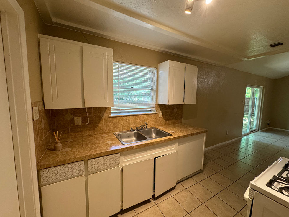 a kitchen with white cabinets and a sink