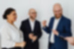 Professional finance recruiters smiling and talking during a meeting.