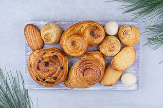various-sweet-pastries-rolls-with-cookies-wooden-board.jpeg
