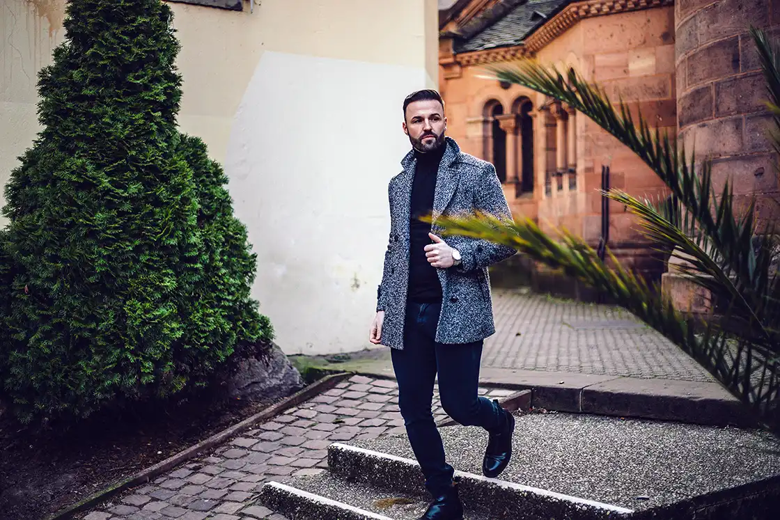 Portrait d'un homme en manteau gris descendant des escaliers