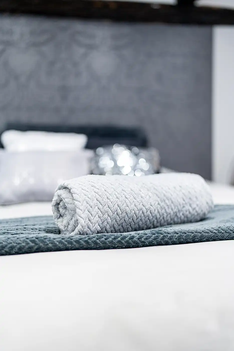Photo immobilier montrant une serviette enroulé sur un lit